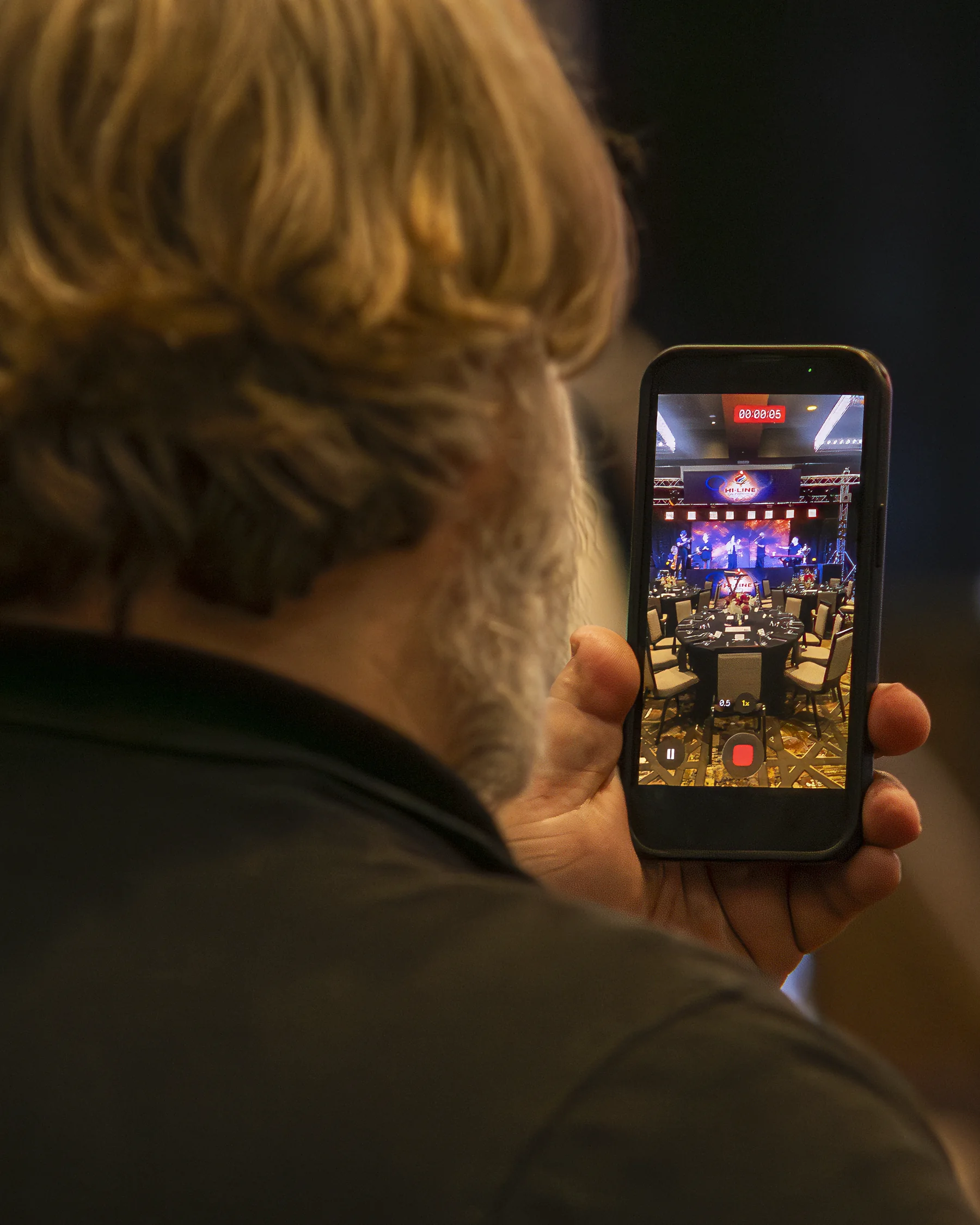 An attendee records the Hi-Line Olympics stage on a phone